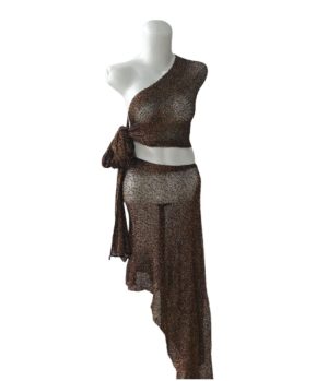 Setelan rajut metalik warna cokelat emas, terdiri dari one-shoulder crop top yang diikat dan rok maxi/midi asimetris transparan.
