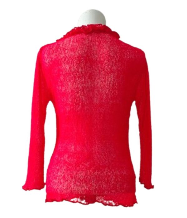 Atasan rajut sheer lengan panjang merah dengan detail frill (kerutan) di leher dan wavy hemline di punggung.